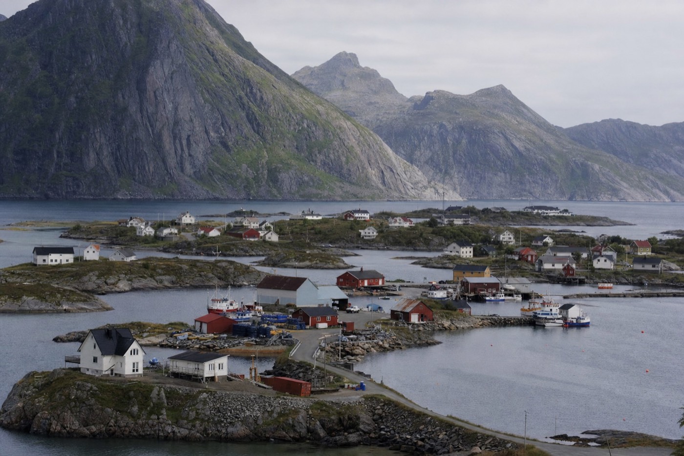 A fishing village built across small rocky islets in Henningsvaer, Lofoten, with steep mountains behind
